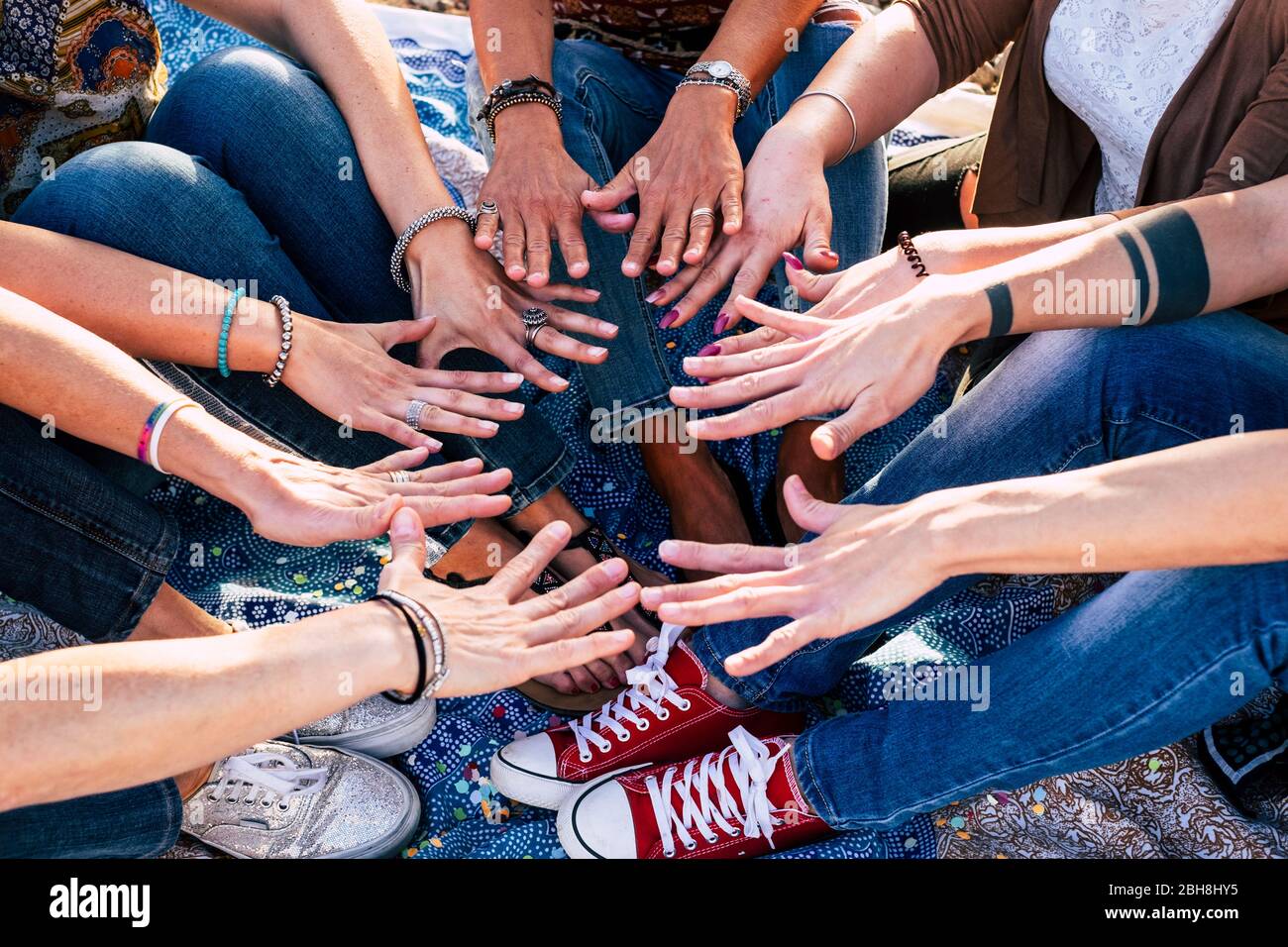 Primo piano vista dall'alto delle persone che mettono le mani insieme. Amici con pile di mani che mostrano unità e lavoro di squadra - gente caucasica in amicizia - stile casual hipster - età diversità Foto Stock