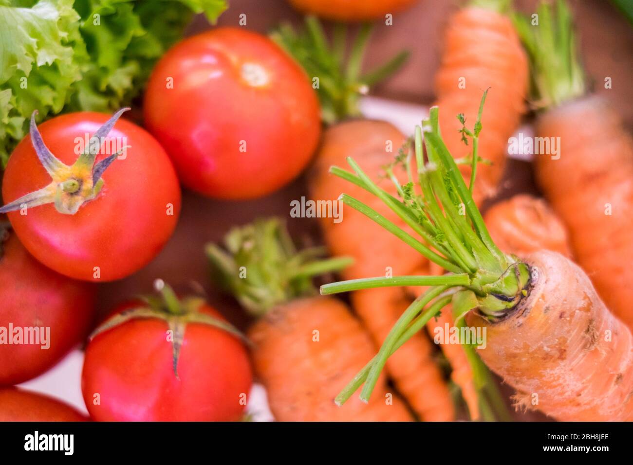 Preparati a verdure miste a colori come carote, pomodori e insalate con tanti colori e un concetto di stile di vita sano per la dieta e il benessere. Cibo fresco per una vita piacevole. Concetto vegetariano e vegano Foto Stock