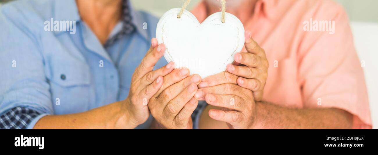 San Valentino concetto di giorno coppia uomo e donna anziano prendendo il cuore bianco di legno insieme - closeup amore espressione per l'intera vita insieme per sempre nella felicità Foto Stock