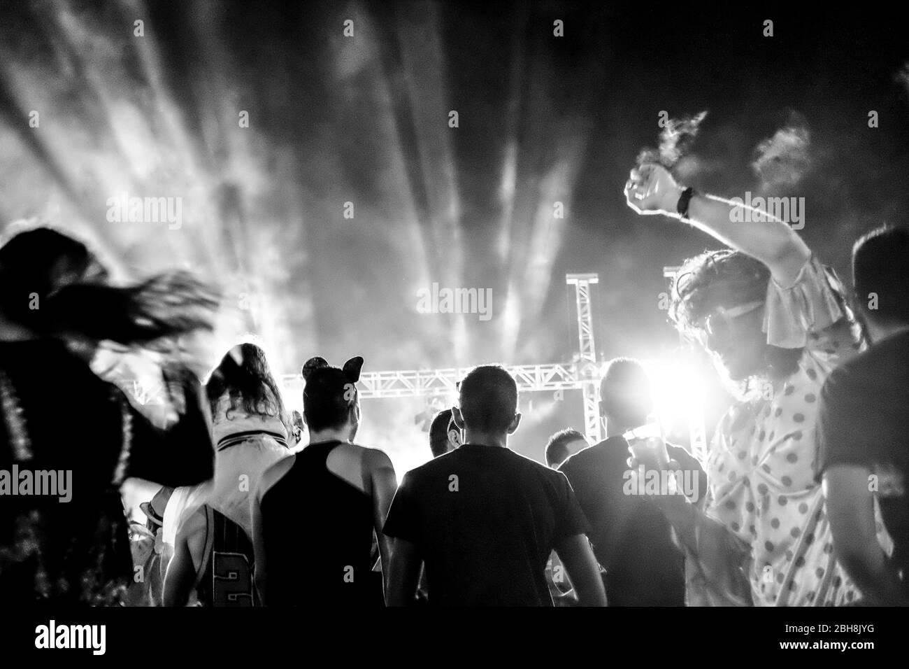Concerto di musica dal vivo con persone con maschere in festa di carnevale sul palco - dj set e canto di gruppo e persone che ballano e divertirsi insieme in amicizia Foto Stock