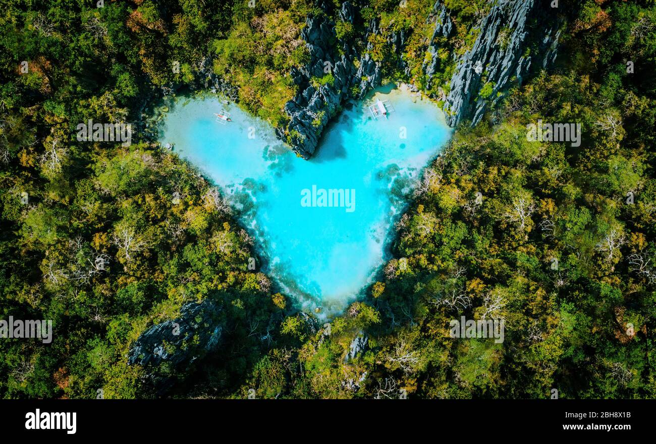 Vista dall'alto del cuore turchese a forma di laguna all'interno dell'isola tropicale. Love viaggio estivo concetto vacanza. Foto Stock