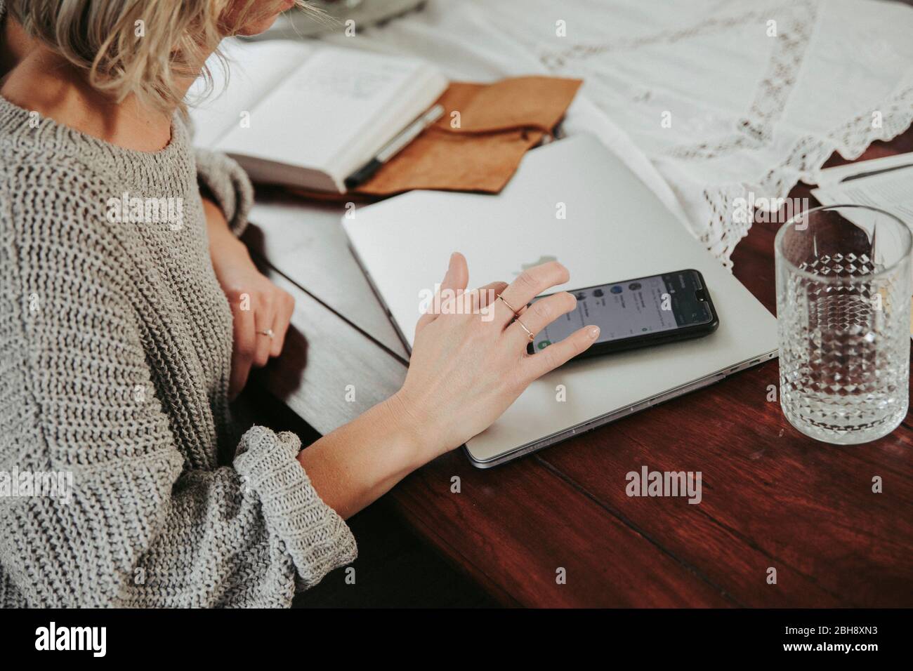 Frau mit smartphone, laptop e notizie Foto Stock