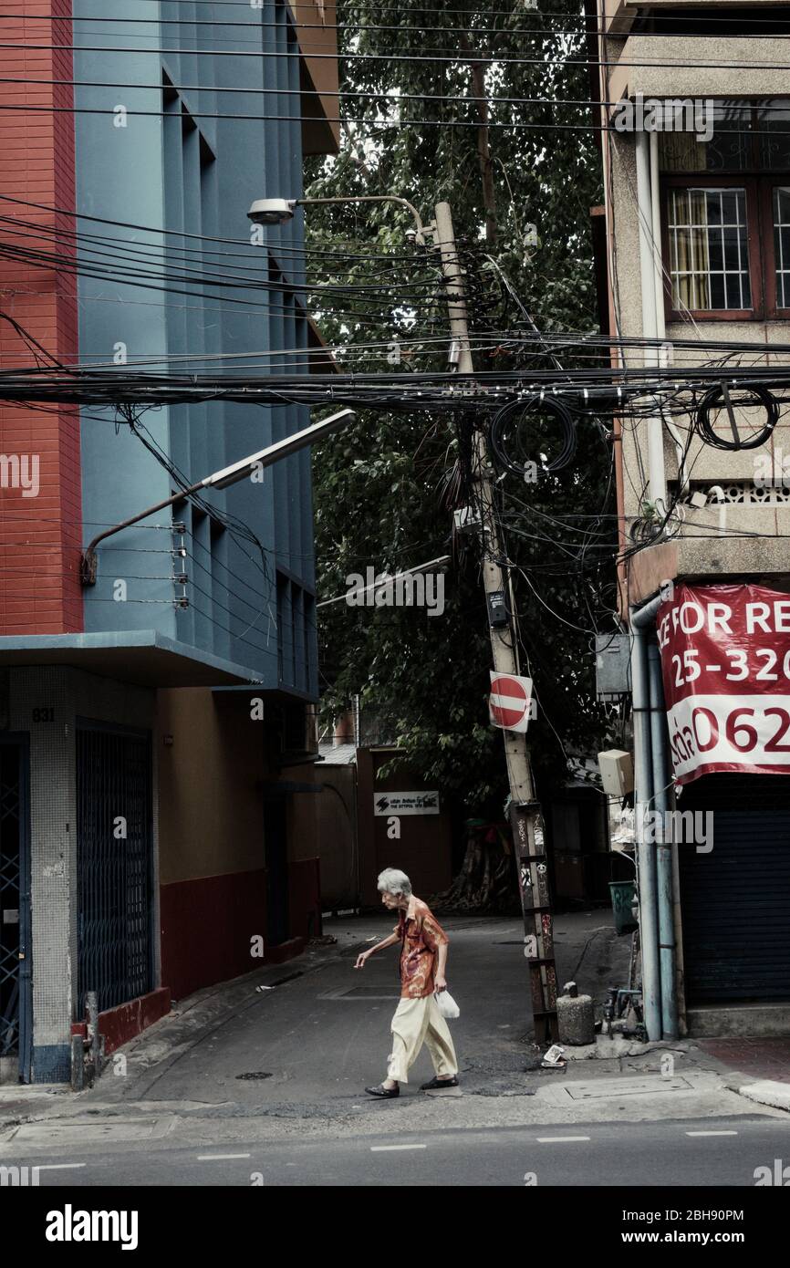 Paesaggio urbano di Bangkok con vecchia donna tailandese sulla strada Foto Stock