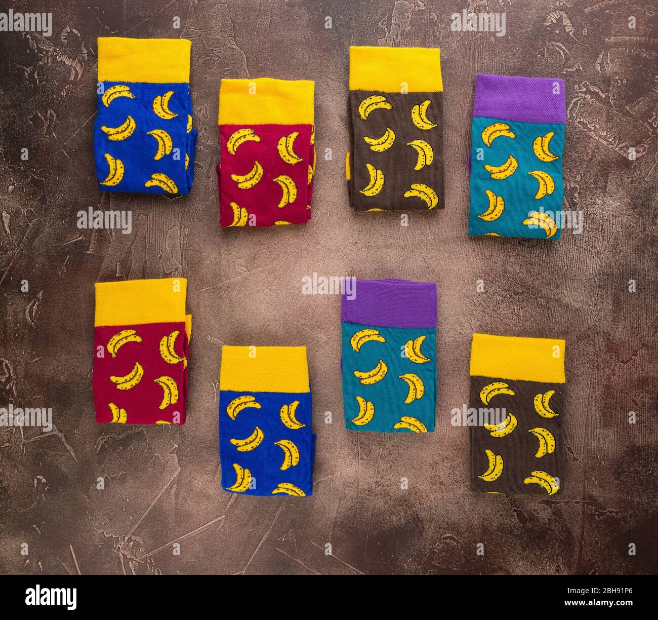 Calze multicolore con motivo di banane su fondo marrone Foto Stock
