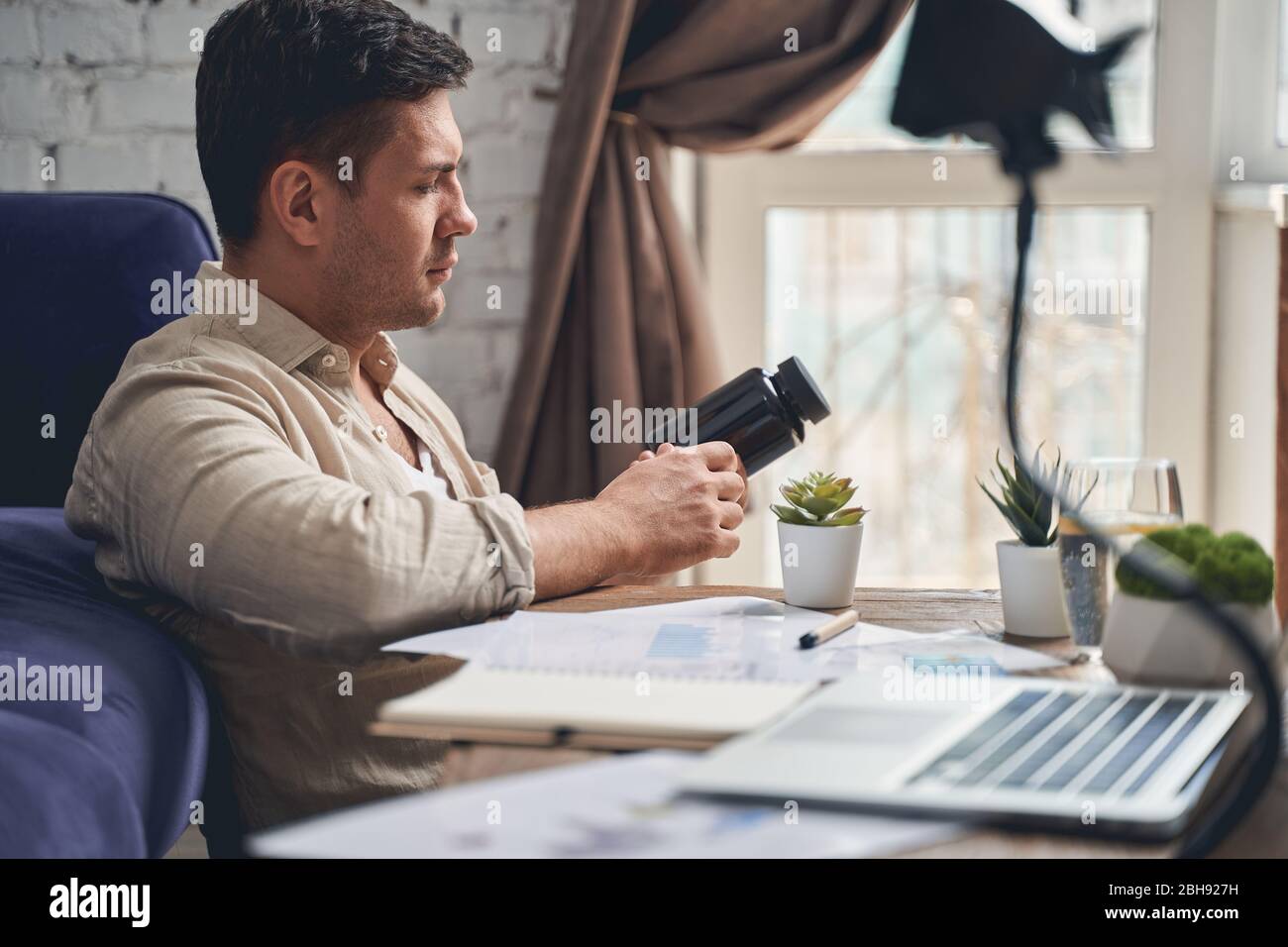 Uomo a capelli scuri con un vaso in plastica Foto Stock