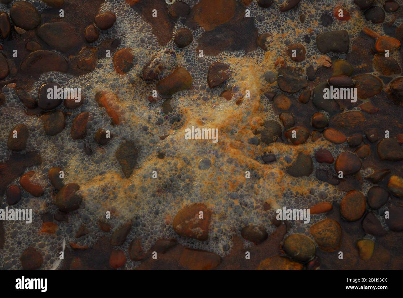 rocce colorate su una spiaggia di sabbia rossa Foto Stock