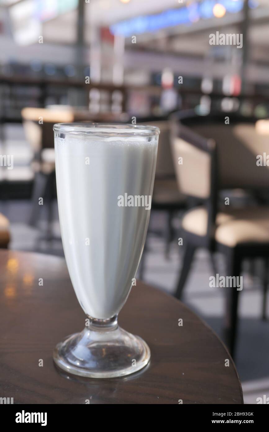 Primo piano di scuotimento del latte sul tavolo del caffè. Foto Stock