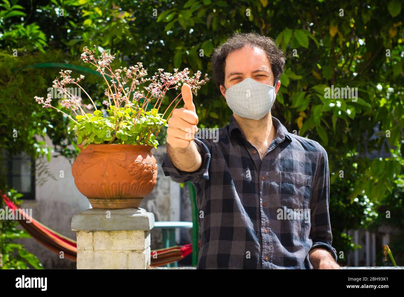 Giovane con maschera di prevenzione facendo il segno 'ok' Foto Stock