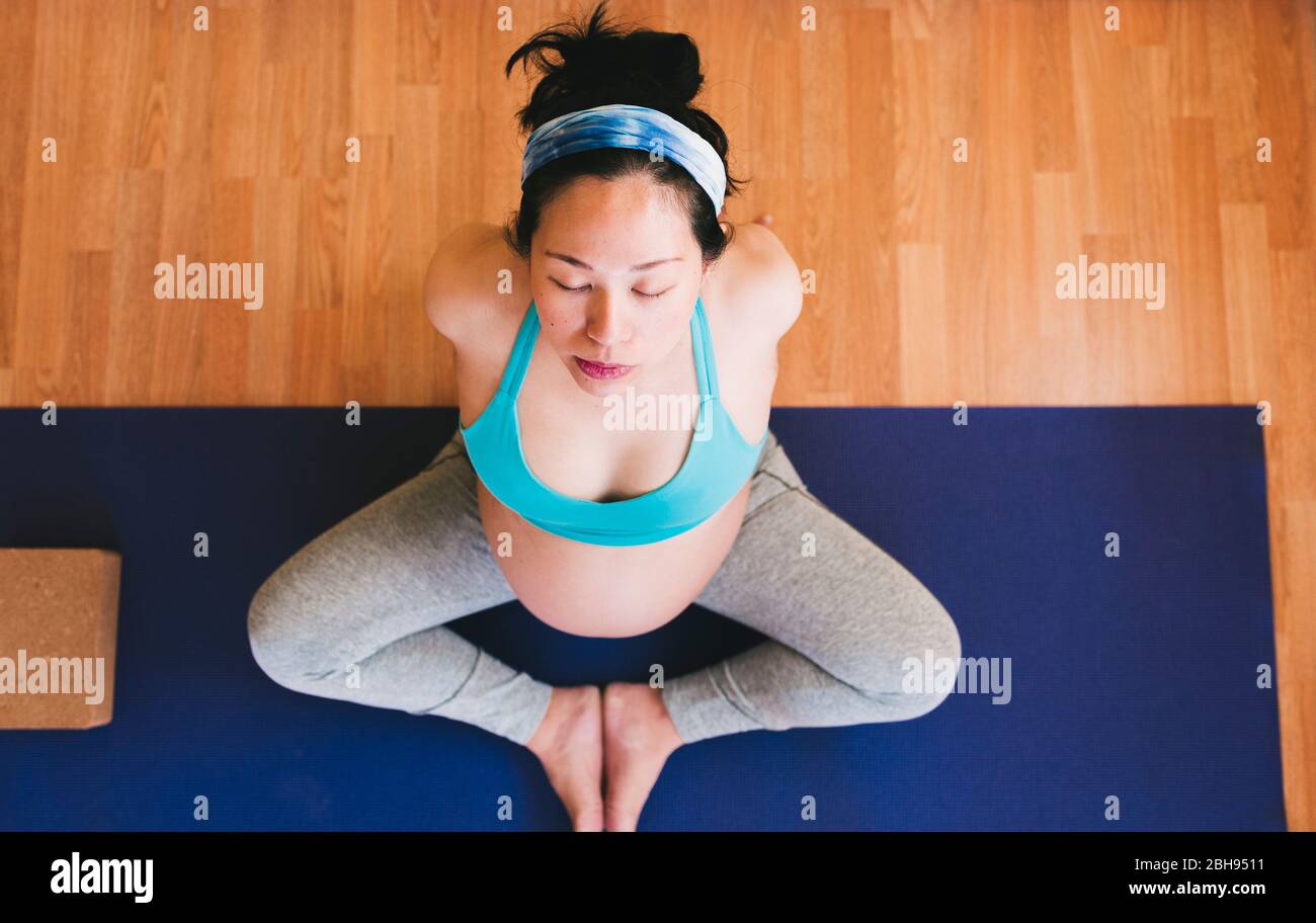 Foto zenithal: Donna dello Yoga incinta su un mat Yoga Foto Stock