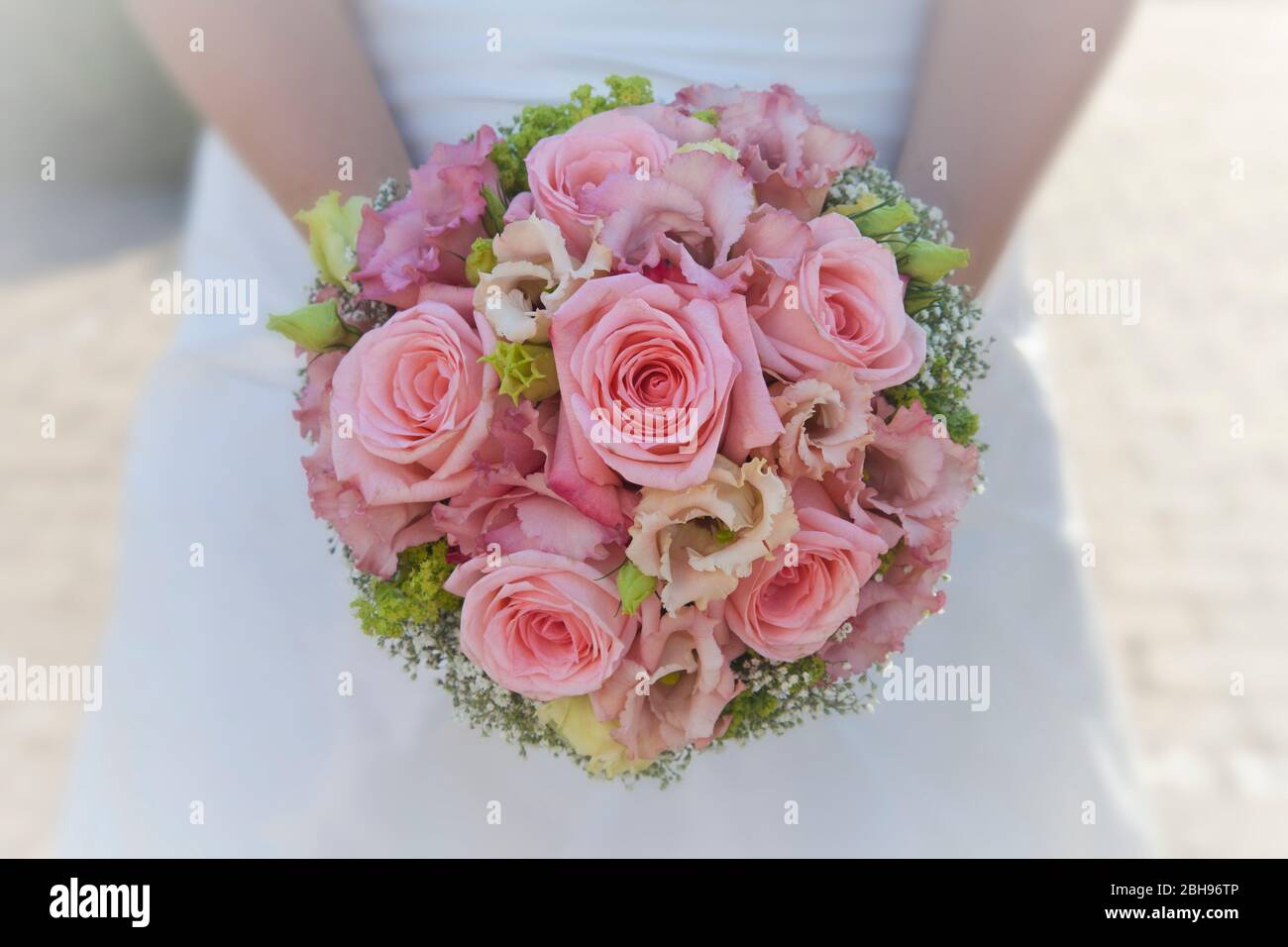 Sposa tiene in mano il bouquet nuziale rosa, primo piano Foto Stock