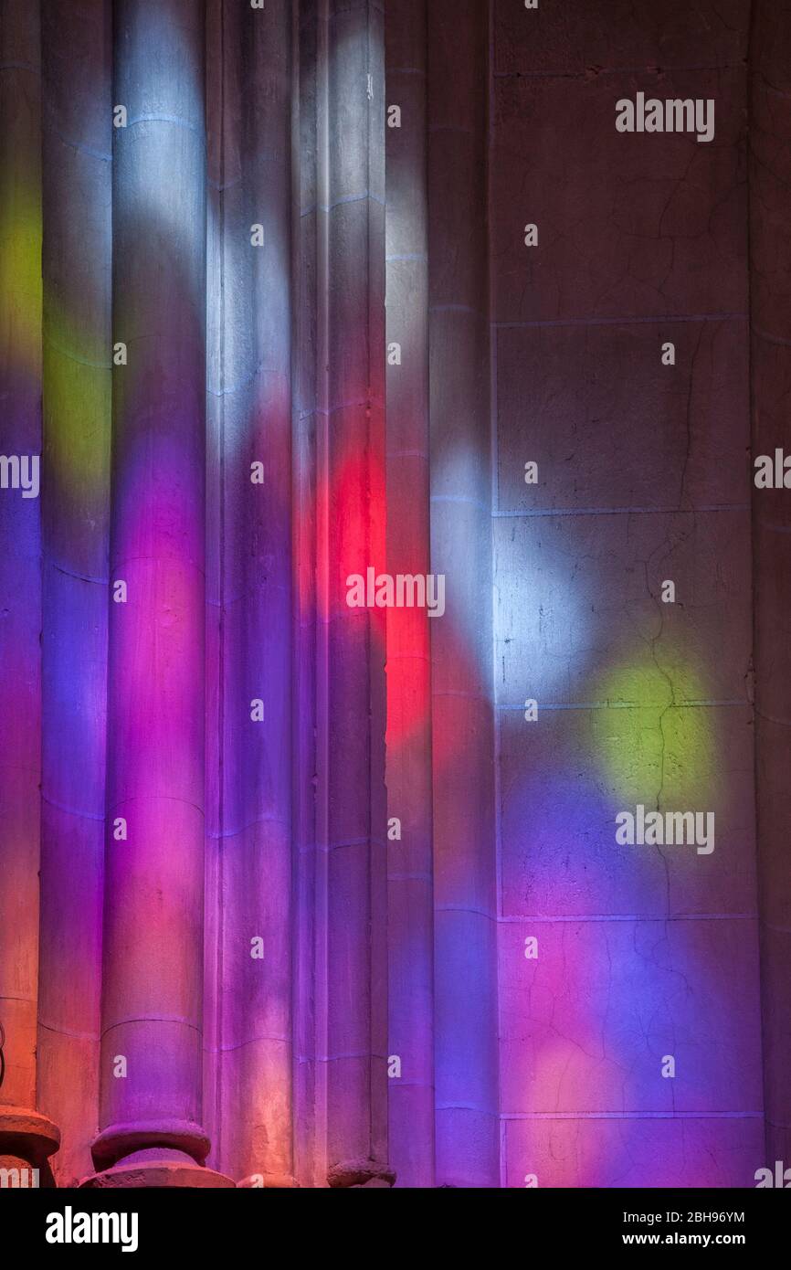 Giochi di luci colorate da vetrate su colonne in una chiesa, Andalusia, Spagna, Carmona, Iglesia Prioral de Santa Maria, Foto Stock