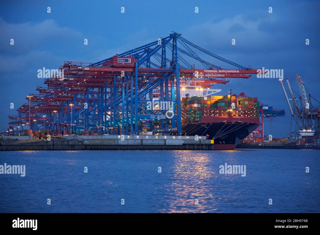 Porto di Waltershofer, Amburgo. Container freighter al terminal illuminato di sera Burchardkai. Foto Stock