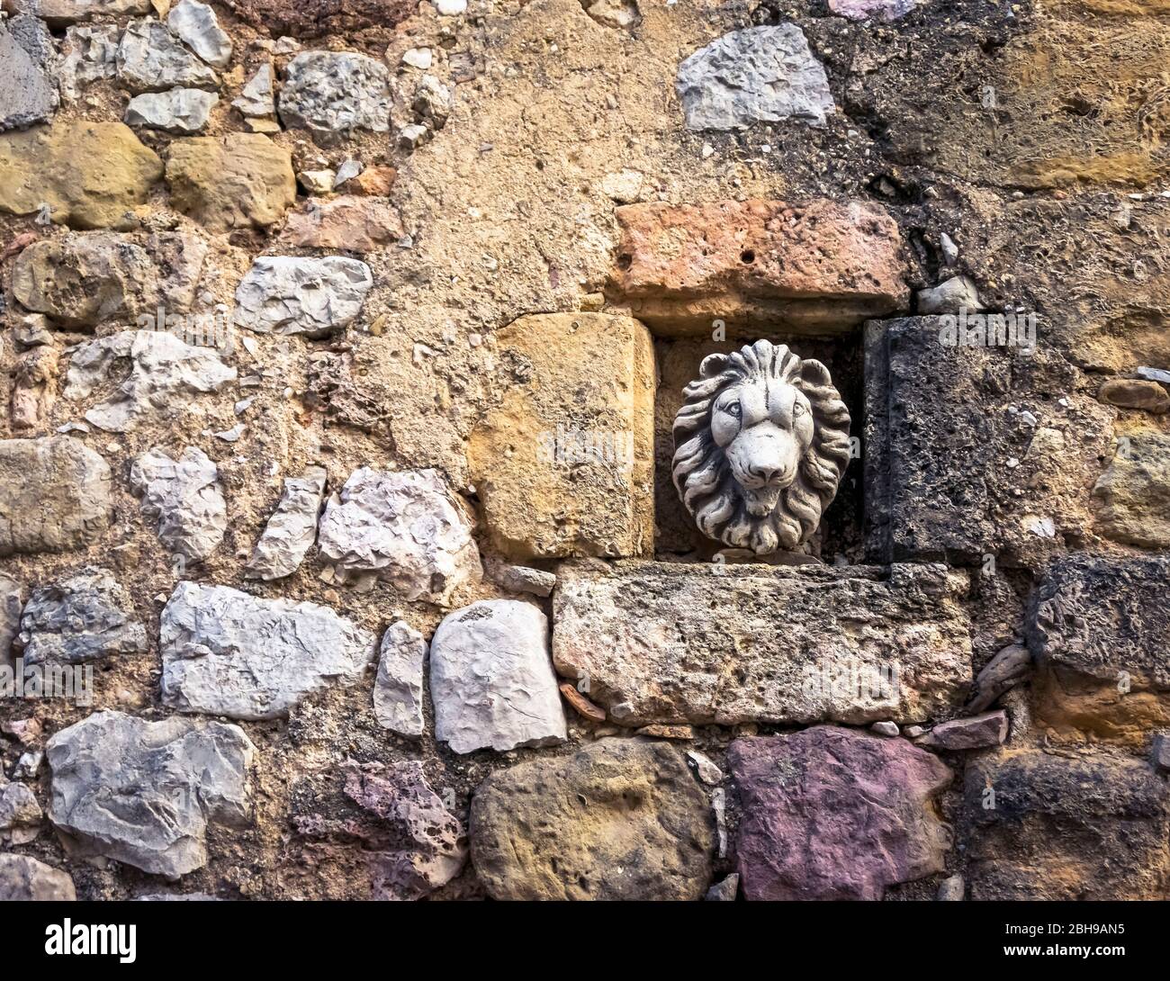 Muro di pietra con testa di leone a Montouliers Foto Stock