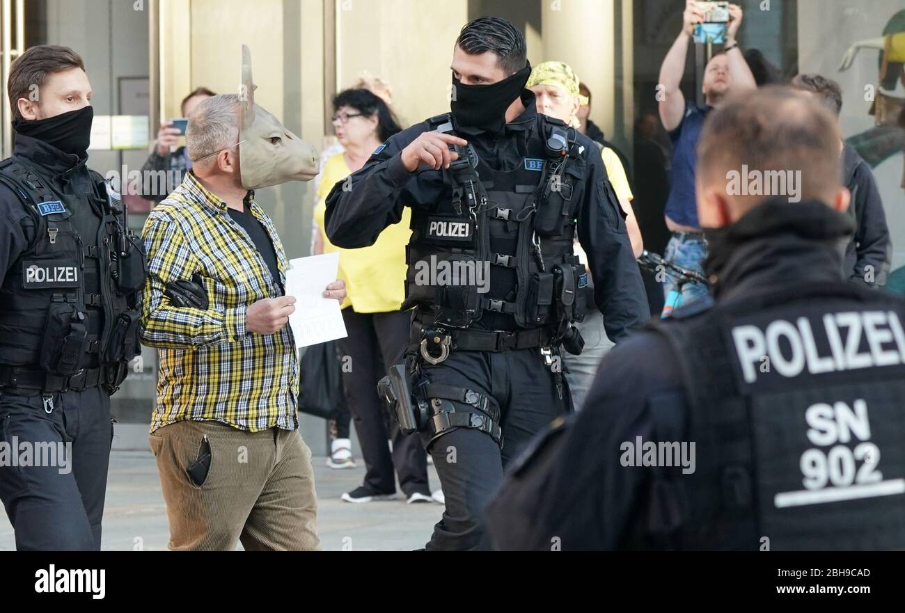 Chemnitz, Germania. 24 Aprile 2020. Un uomo che indossa una maschera viene preso da poliziotti per l'identificazione personale. I membri dell'associazione estremista di destra Pro Chemnitz avevano pianificato un raduno al monumento Karl Marx. Dopo che la manifestazione fu vietata dalla Corte amministrativa superiore Sassonia, la polizia sciolse gruppi di manifestanti da Pro Chemnitz. Credit: Peter Endig/dpa-Zentralbild/dpa/Alamy Live News Foto Stock