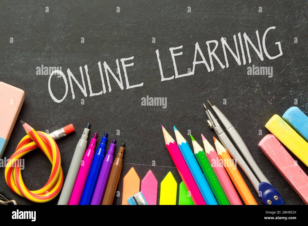 Apprendimento online in quarantena iscrizione sullo sfondo di una lavagna e forniture scolastiche .Homeschooling durante la quarantena. A casa, studio in Th Foto Stock