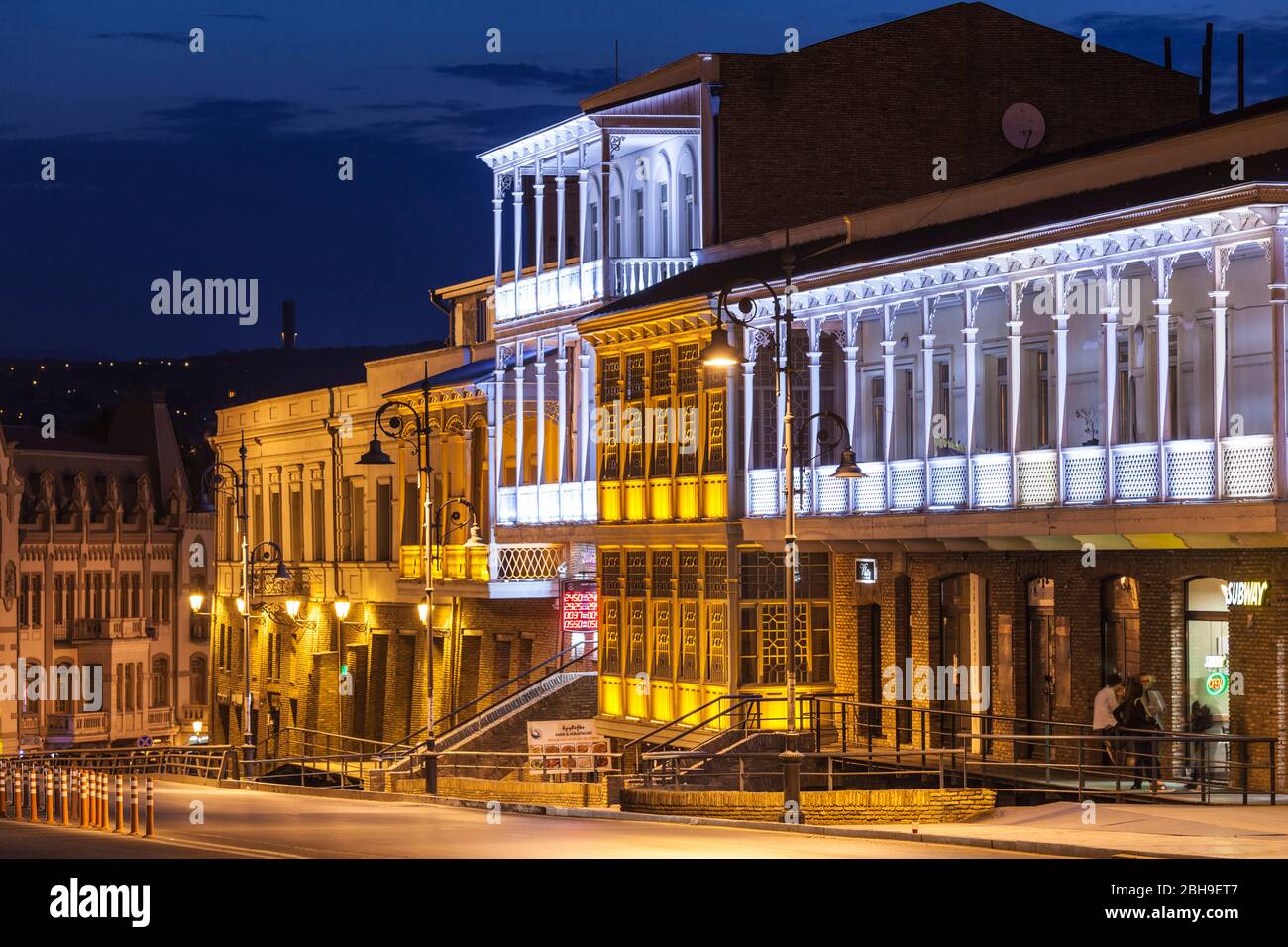 La Georgia, Tbilisi, edifici illuminati lungo via Pushkin, alba Foto Stock