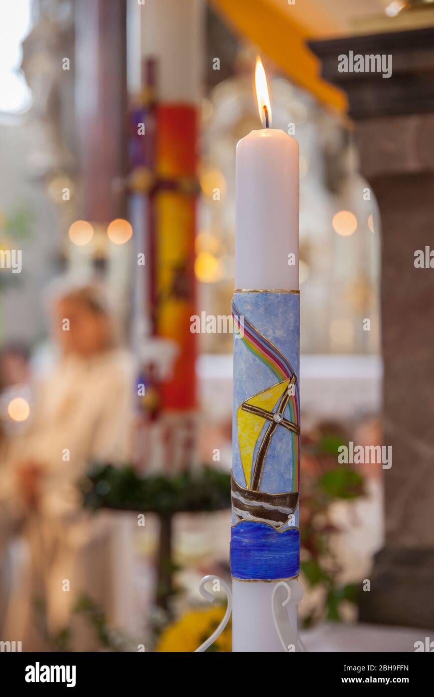 Candela di comunione e candela pasquale alla celebrazione della comunione in chiesa Foto Stock