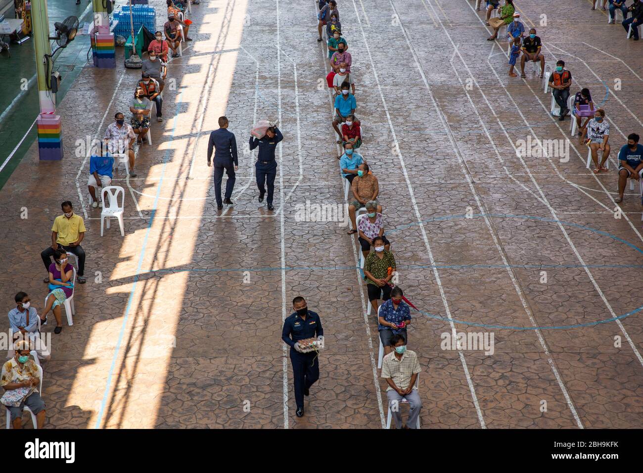 Bangkok, Thailandia. 24 Aprile 2020. La gente aspetta in fila per ricevere pasti gratuiti per aiutare a combattere la perdita di reddito a causa del COVID-19 alla scuola di Wat Don Muang. 300 famiglie hanno accettato il cibo gratuito, con un'alimentazione stimata di 1500 persone sulla base della dimensione media della famiglia. Il cibo è stato agevolato dalla Thai Airforce per garantire adeguate misure di distanza sociale. Credit: Andre Malerba/ZUMA Wire/Alamy Live News Foto Stock
