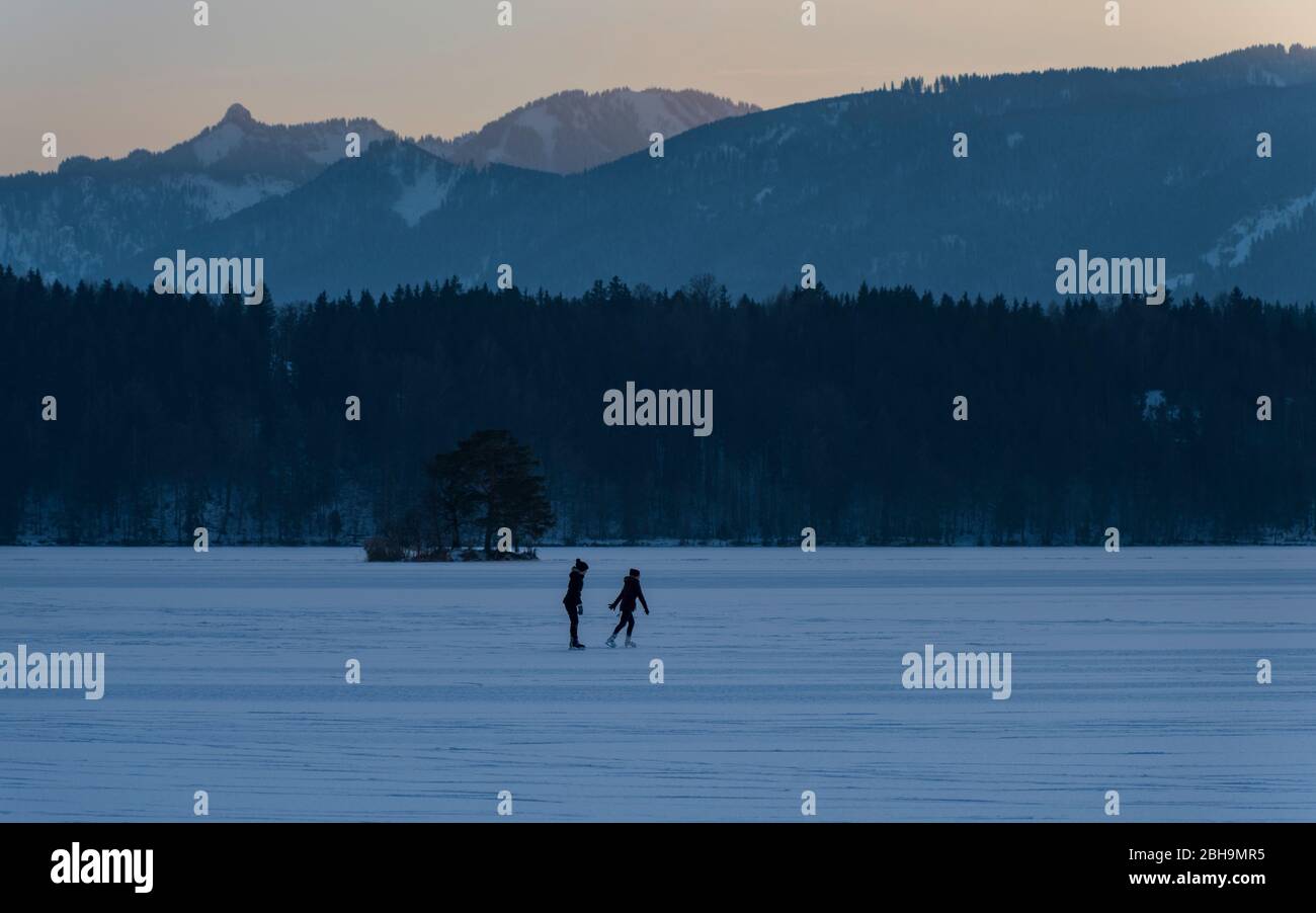 Impressioni invernali nella regione intorno a Murnau, alta Baviera. Donna e ragazza praticano il pattinaggio su ghiaccio Foto Stock