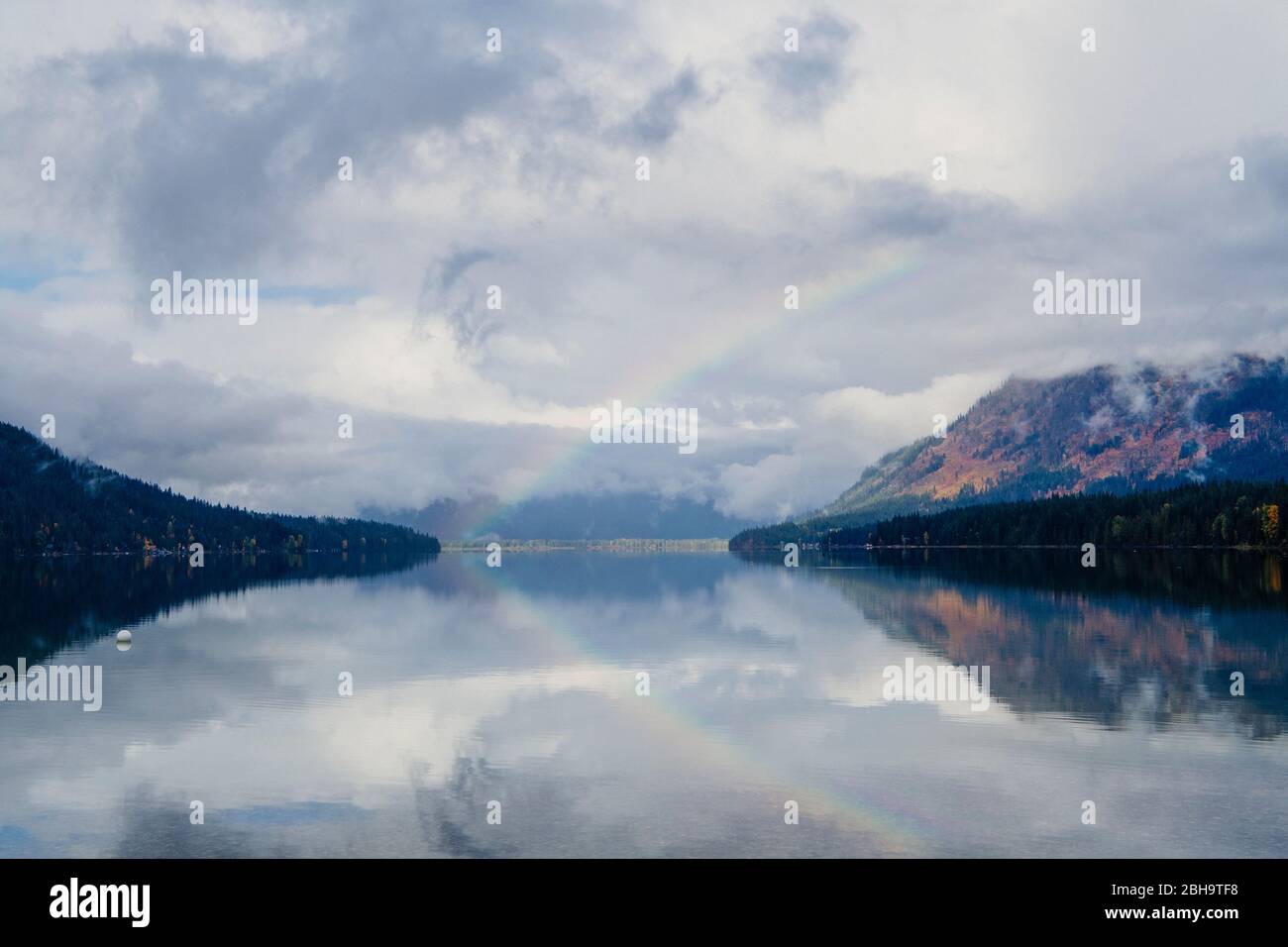 Arcobaleno sul lago e la montagna in giornata nuvolosa, Lake Wenatchee state Park, Wenatchee, Washington, USA Foto Stock