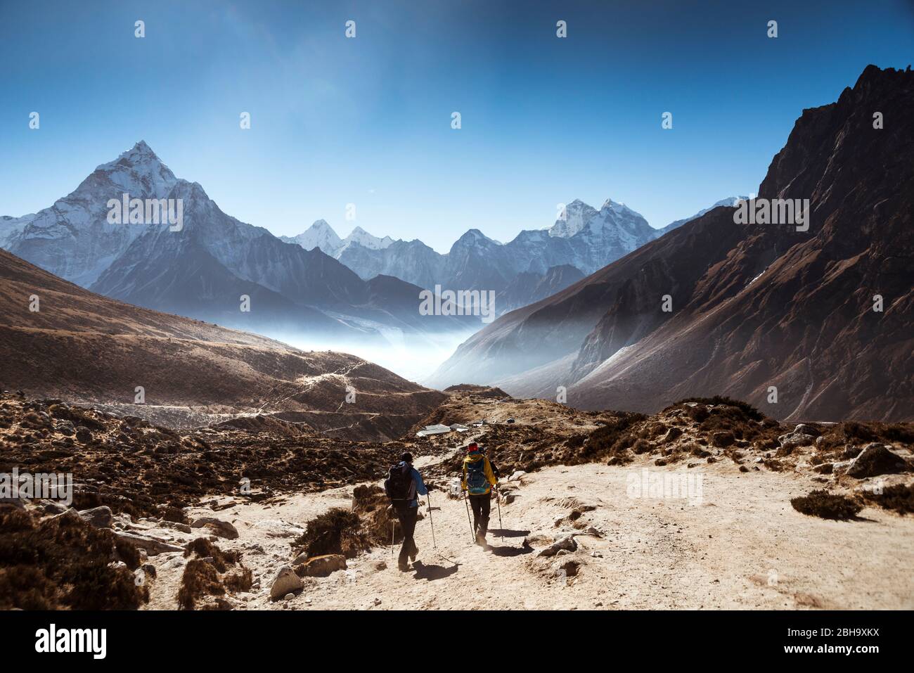 due escursionisti dal retro, montagne sullo sfondo, sulla strada per la valle, Foto Stock