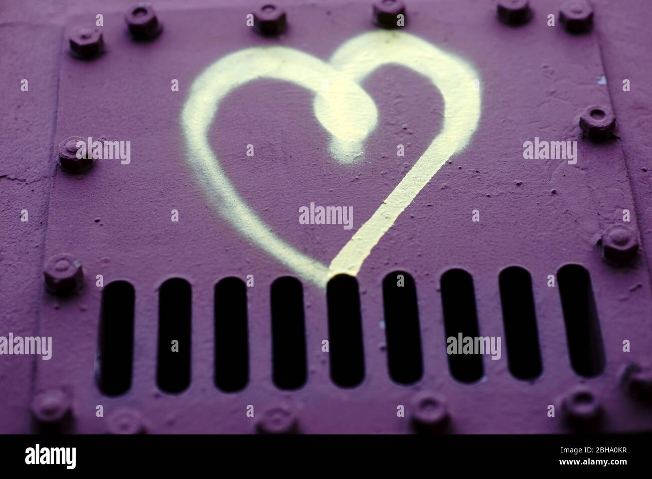 Un cuore disegnato sulla superficie metallica del rivetto in acciaio. Foto Stock