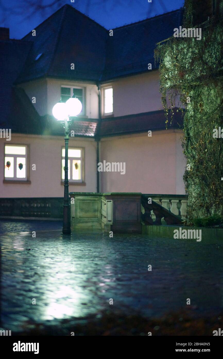 Lanterna si accende una stretta rainy posto nella parte anteriore di un edificio residenziale. Foto Stock