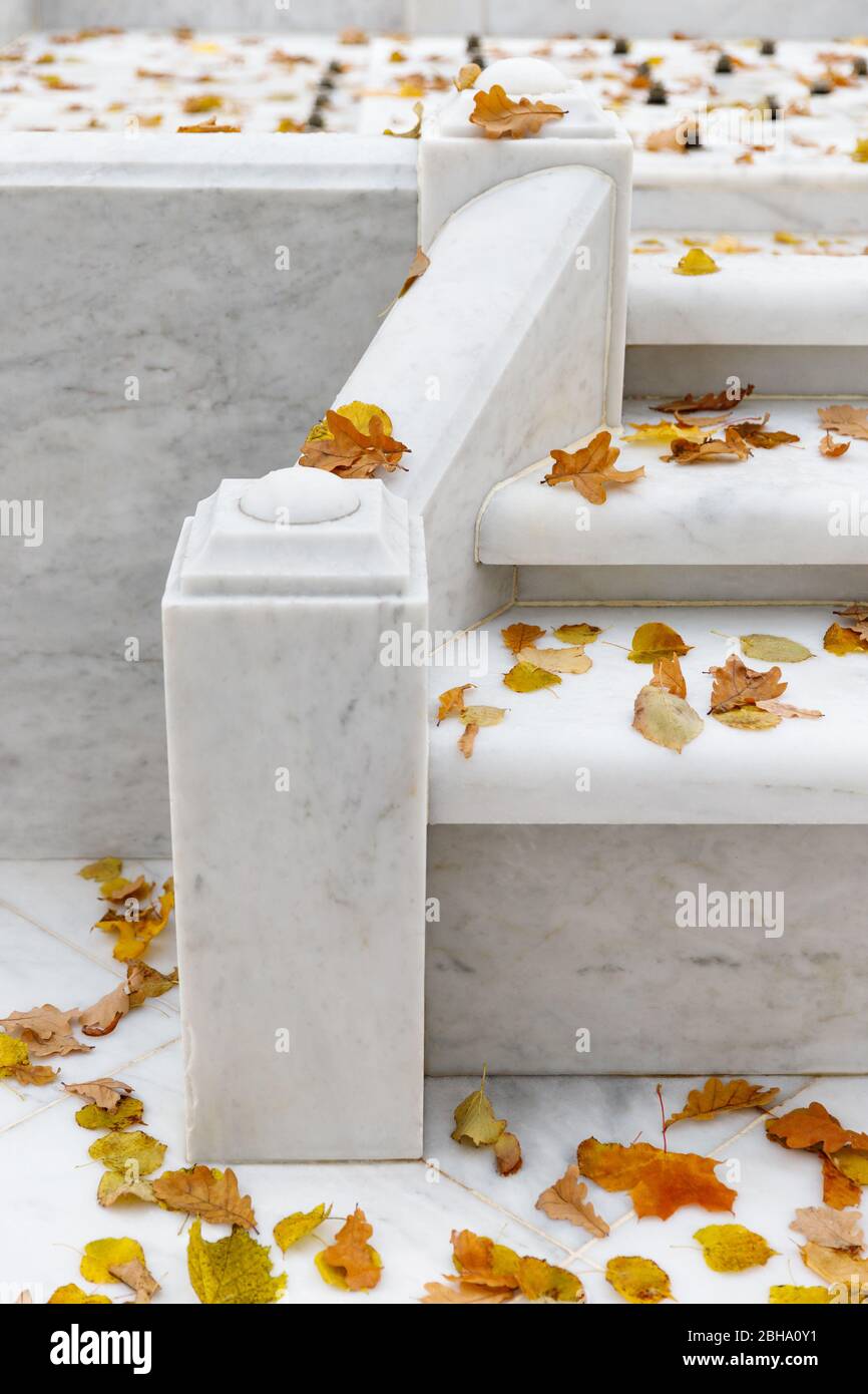 Primo piano della fontana di marmo bianco presso il Giardino estivo pubblico di San Pietroburgo. La fontana è spenta per l'inverno, foglie cadute asciutte sui gradini. Foto Stock