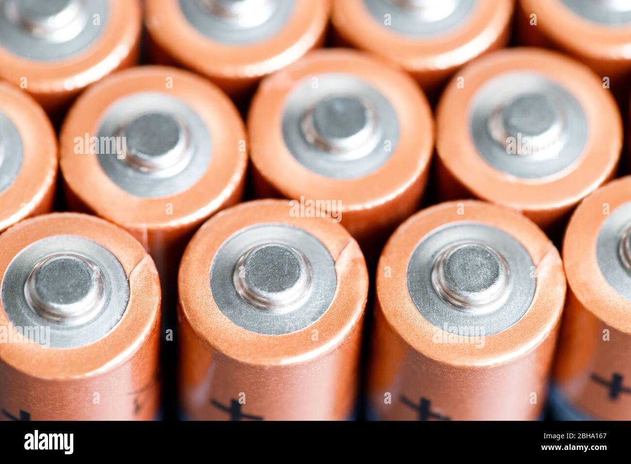 Primo piano delle estremità positive delle celle della batteria a file, vista dall'alto, messa a fuoco morbida. Batterie alcaline AA usate. Foto Stock