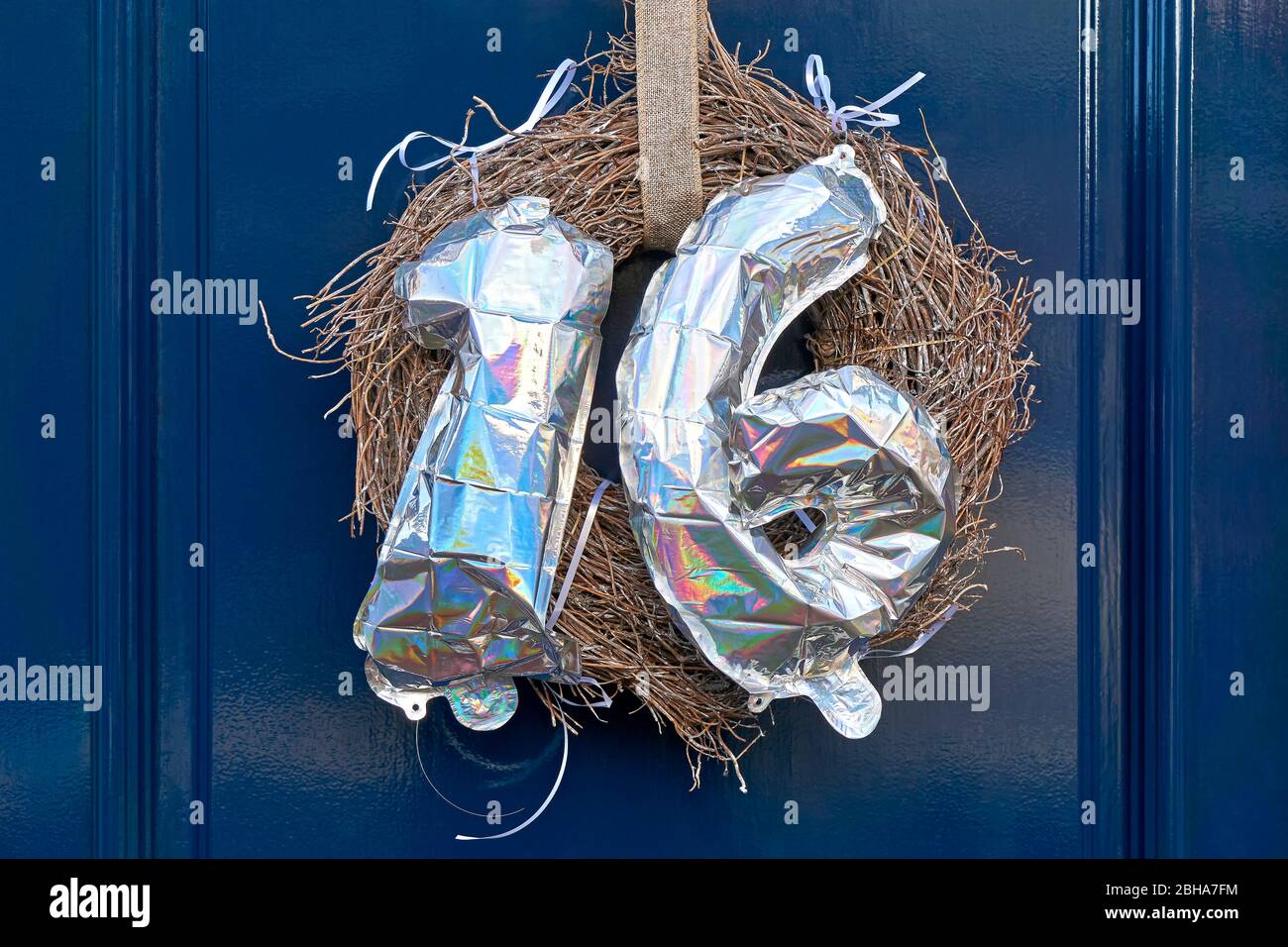 Numero 16 sedici di colore argento fatto di palloncini gonfiabili su porta blu scuro. Dolce concetto di sedici anni. Foto Stock