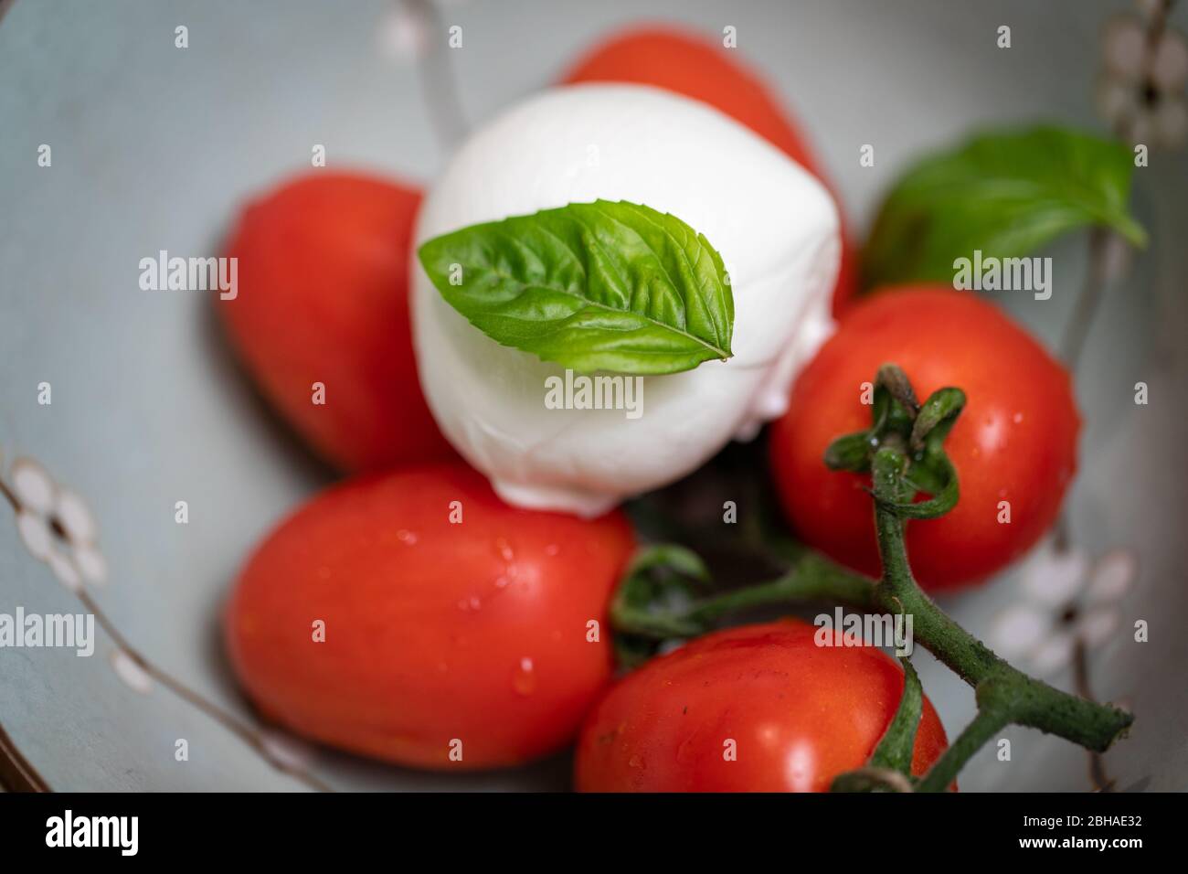 deliziosa insalata di caprese, pomodori maturi, mozzarella di bufala e deatail al basilico, cucina tradizionale italiana Foto Stock