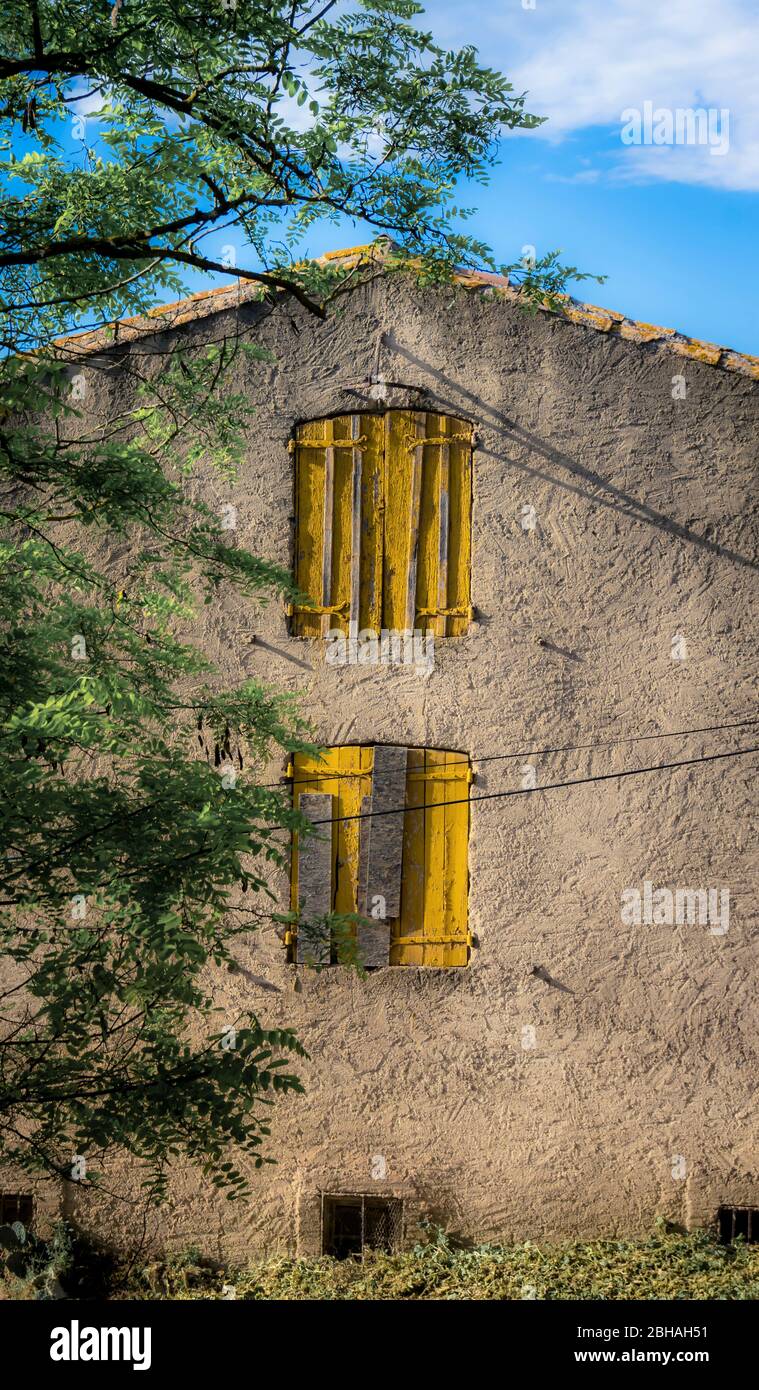 Vecchia casa con persiane gialle a Montady Beziers Foto Stock