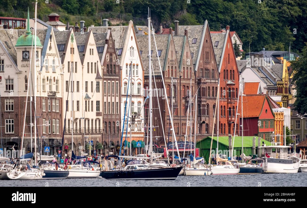 Barche a vela di fronte ad una fila di case nel quartiere anseatico di Bryggen vicino Bergen havn, Hordaland, Norvegia, Scandinavia, Europa Foto Stock