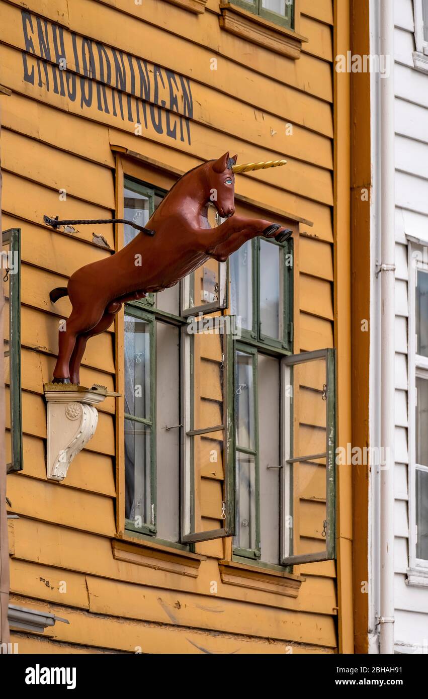Figura colorata in legno di un unicorno sul muro di una storica casa in legno nel quartiere anseatico di Bryggen, Torget, il Molo Tedesco, Bergen, Hordaland, Norvegia, Scandinavia, Europa Foto Stock