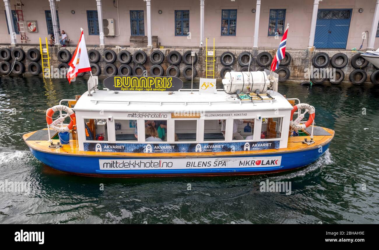 Tour in barca colorata con bandiere risalzate sul molo a Bergen, Hordaland, Norvegia, Scandinavia, Europa Foto Stock