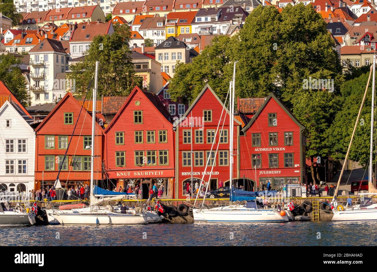 Nordsee, dietro una colorata case in legno fronte con allegata barche a vela nel porto di Bryggen, circa altre case della città, Bergen, Hordaland, Norvegia, Scandinavia, Europa Foto Stock