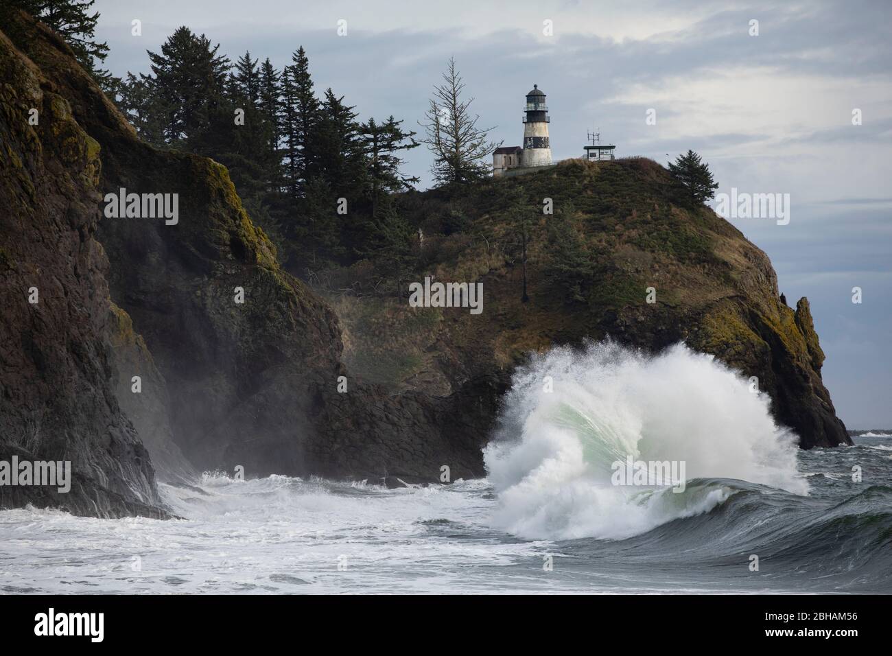 Onde e faro in crash, Cape Disappointment state Park, Washington, USA Foto Stock