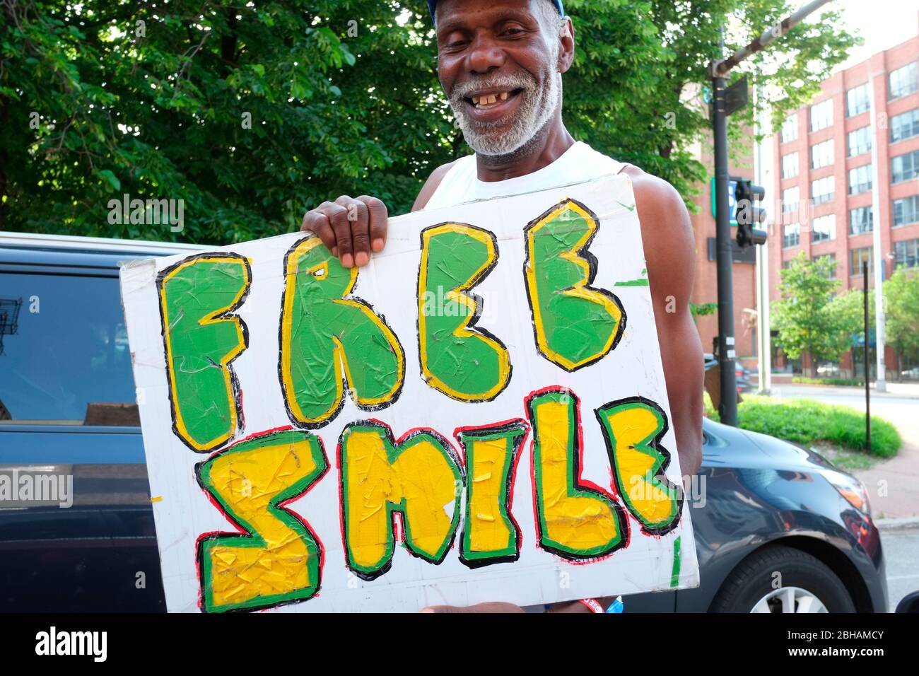 L'uomo che tiene un cartello "Free Smile" sorride nella fotocamera Foto Stock