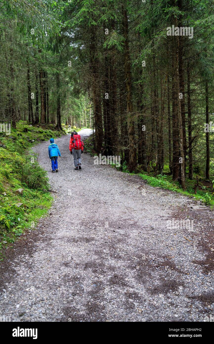 Europa, Austria, Tirolo, Neustift im Stubaital, madre e figlio camminano lungo un sentiero forestale lungo la Wilde-Wasser-Weg verso Grawa Alm Foto Stock