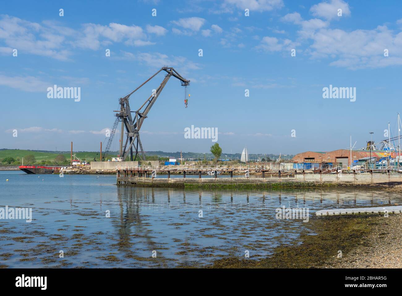 Una grande gru industriale in metallo che riflette sull'acqua, Tipner, Portsmouth UK Foto Stock