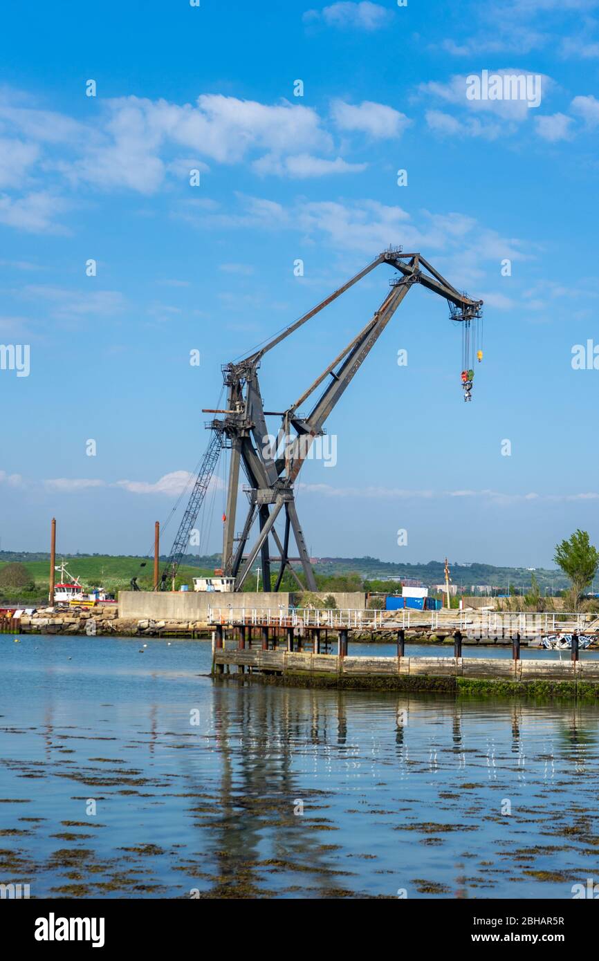 Una grande gru industriale in metallo che riflette sull'acqua, Tipner, Portsmouth UK Foto Stock