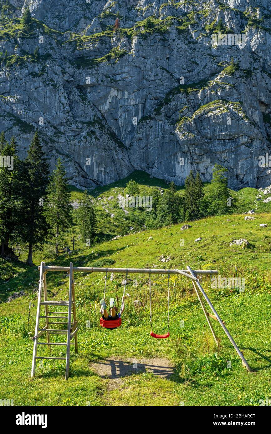 Europa, Deutschland, Bayern, Bayerische Voralpen, Benediktbeuern, Junge schaukelt vor der Benediktenwand Foto Stock