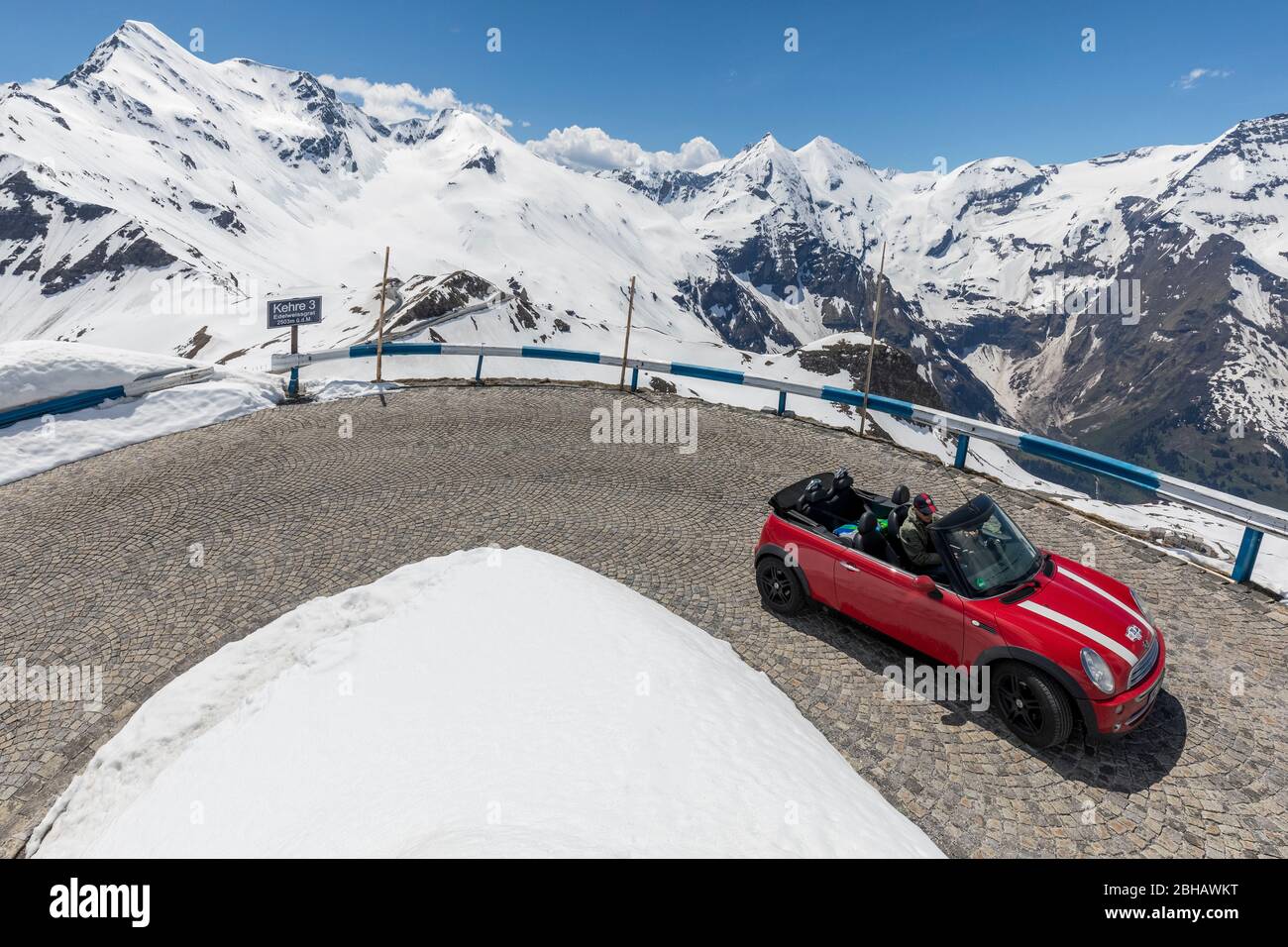 Una macchina rossa all'angolo 3 verso la zona di punta delle stelle spitze, Grossglockner High Alpine Mountain Road, Hohe Tauern National Park, Salisburgo Land, Austria, Europa Foto Stock