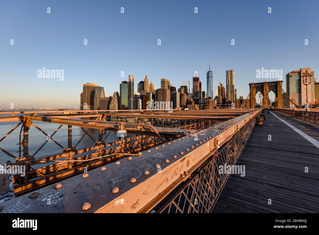 Ammira il deserto del ponte di Brooklyn fino alla silhouette del centro di Manhattan all'alba in estate Foto Stock