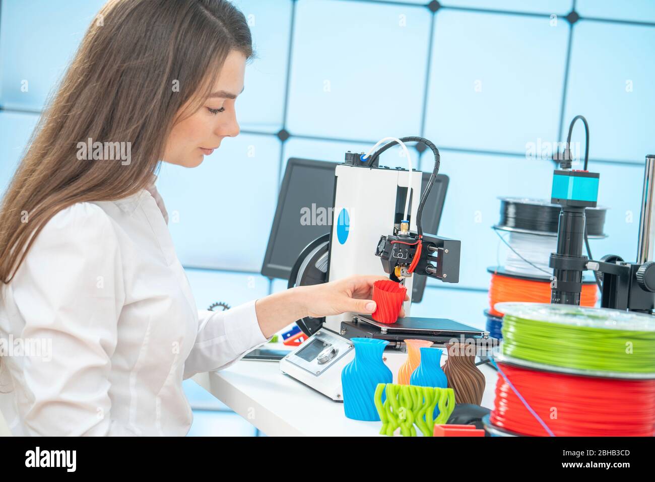 Donna che usa una stampante 3d. Foto Stock