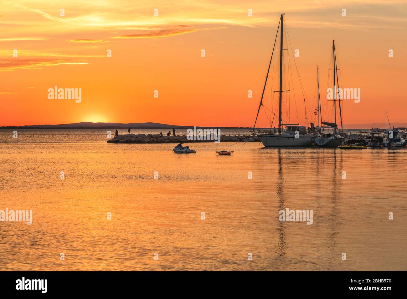 barche ormeggiate ad un piccolo porto turistico di vrsi molo al tramonto, vrsi, contea di zadar, dalmazia, croazia Foto Stock