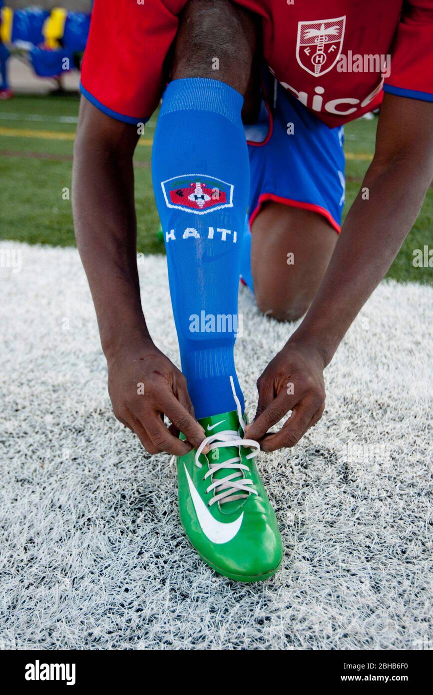 Austin, Texas USA, 28 aprile 2010: Un membro della nazionale di calcio haitiana lega la sua scarpa prima di una partita espositiva con la squadra di calcio professionale Austin Aztek. La struttura di Port au Prince degli haitiani è stata decimata dal terremoto del gennaio 12th e 32 membri della squadra sono stati uccisi. I membri del team sopravvissuti hanno accettato un'offerta di formazione per due settimane in Texas e si recheranno in Argentina la prossima settimana per incontri sudamericani. ©Bob Daemmrich Foto Stock