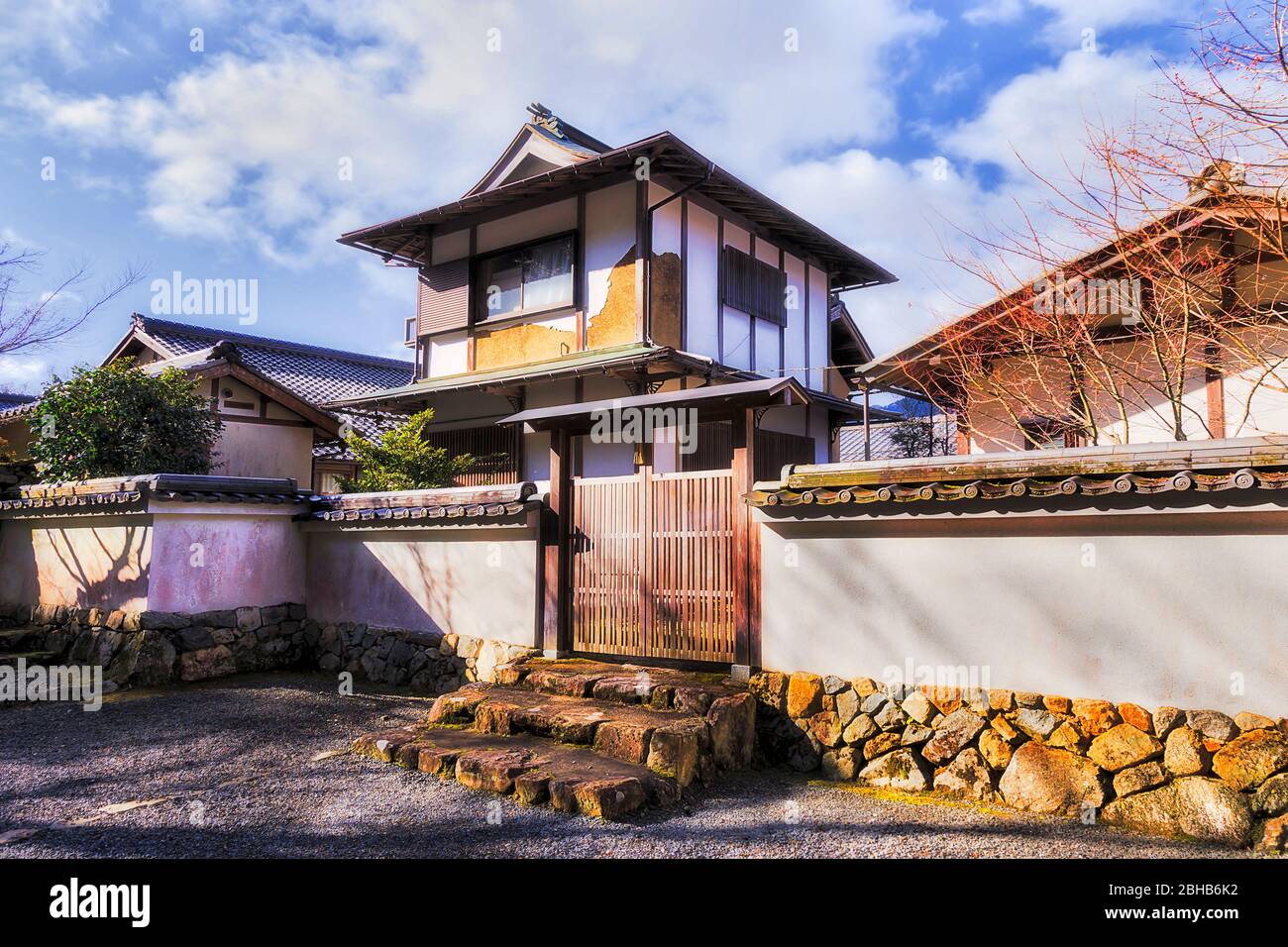 Storica casa residenziale in tradizionale stile architettonico giapponese circondata da pareti bianche con porta in legno nel remoto villaggio di Ohara. Foto Stock