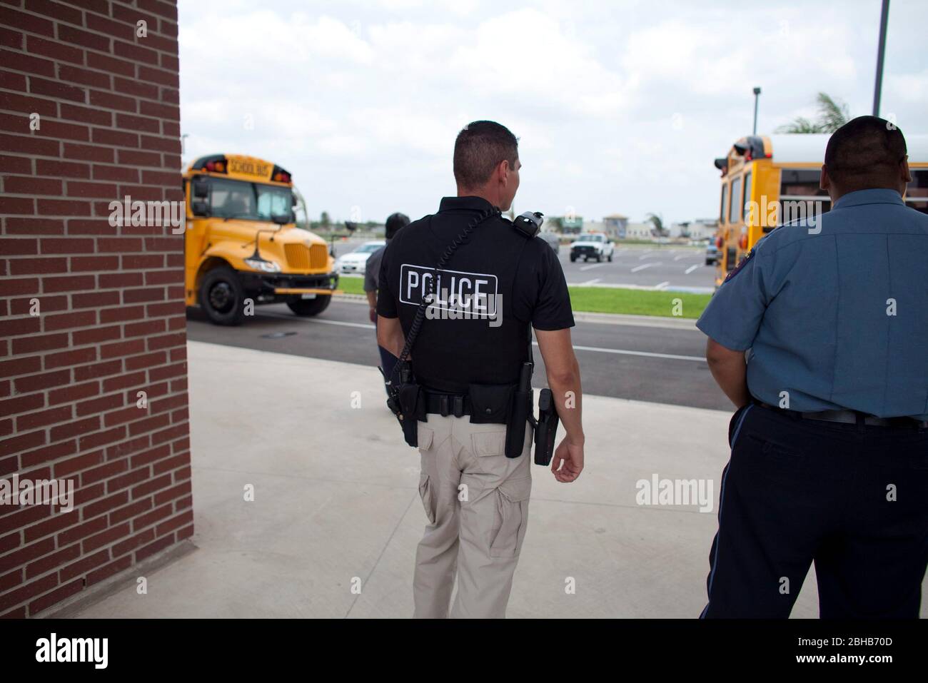 Pharr Texas USA, 13 maggio 2010: Poliziotto armato guarda gli autobus della scuola caricati con gli studenti lasciare la scuola per il giorno. ©Bob Daemmrich Foto Stock