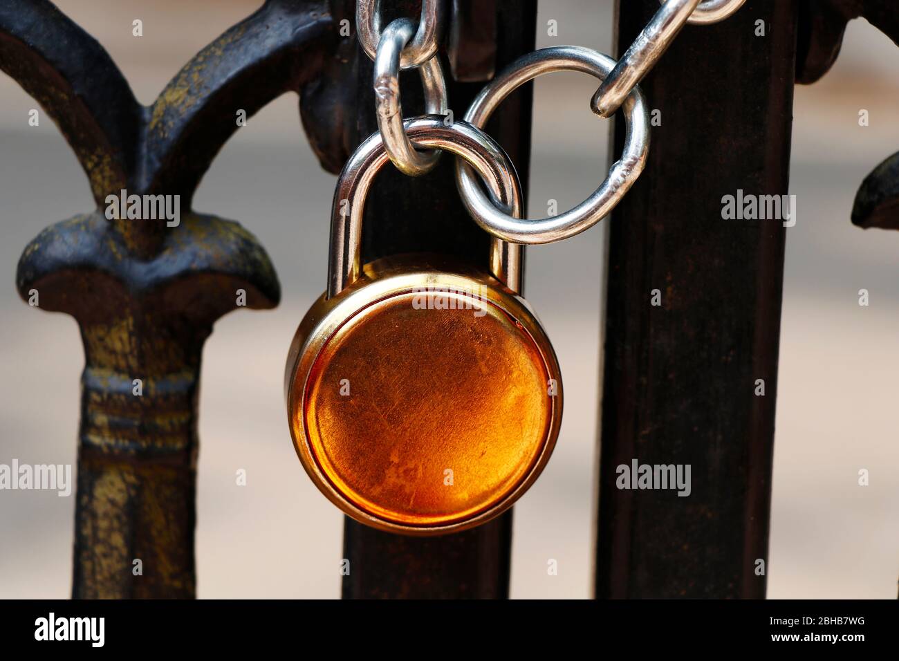 lucchetto e robusta catena in acciaio avvolta intorno al cancello di ingresso in metallo come parte di sicurezza Foto Stock